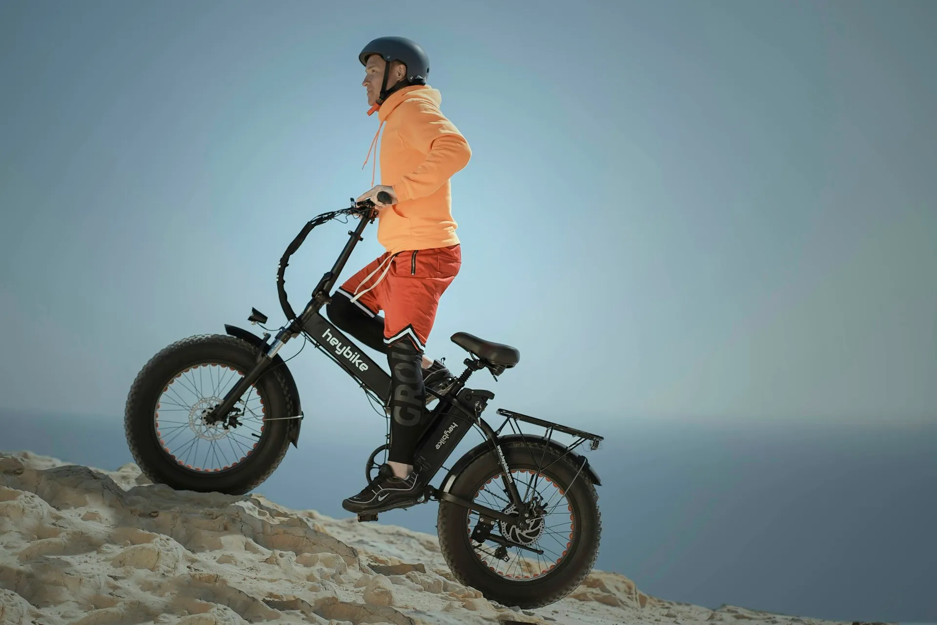Pessoa pilotando uma bike elétrica de pneu largo em trilha ao ar livre.