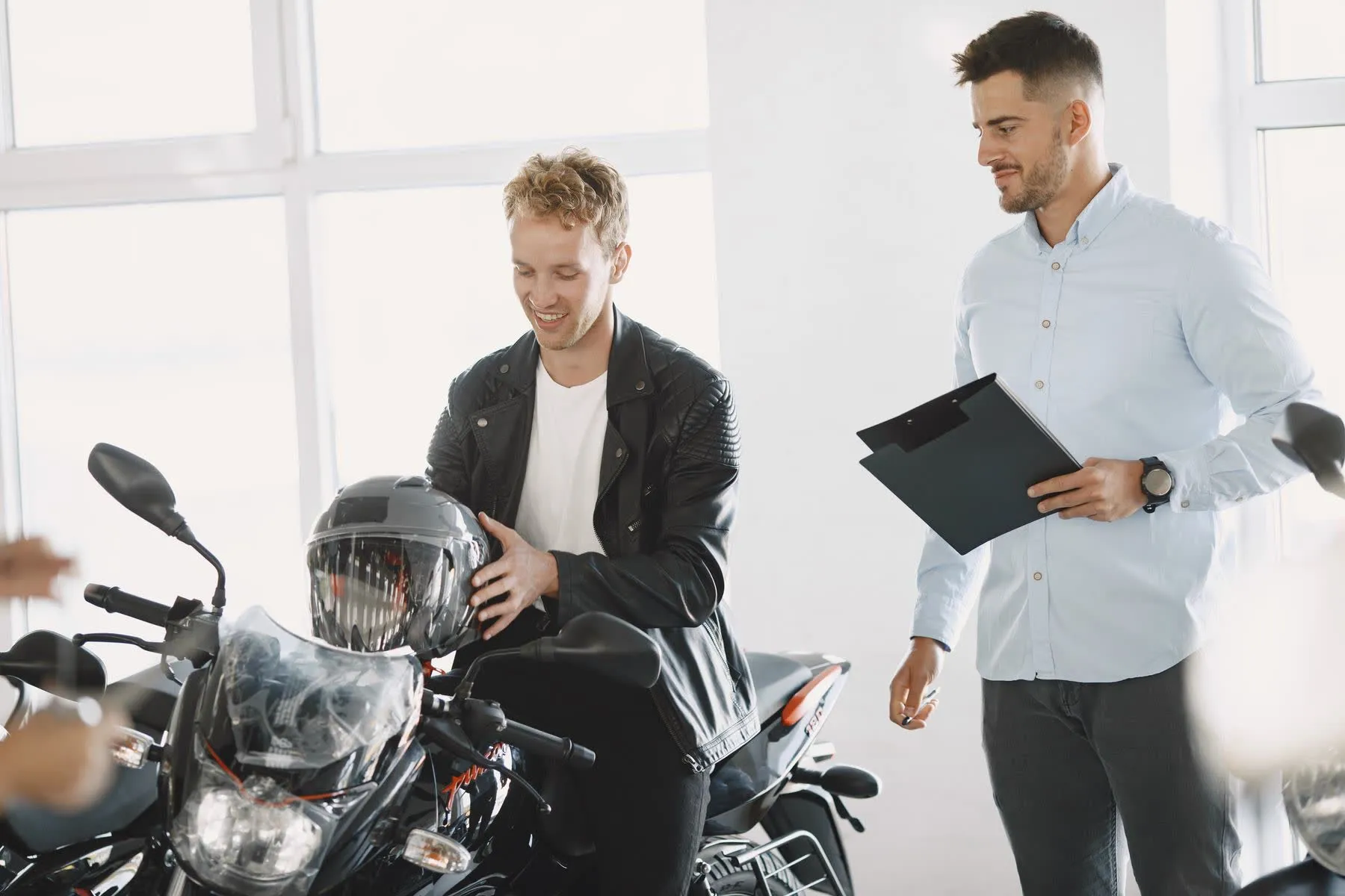 Vendedor com prancheta atendendo um cliente no showroom.