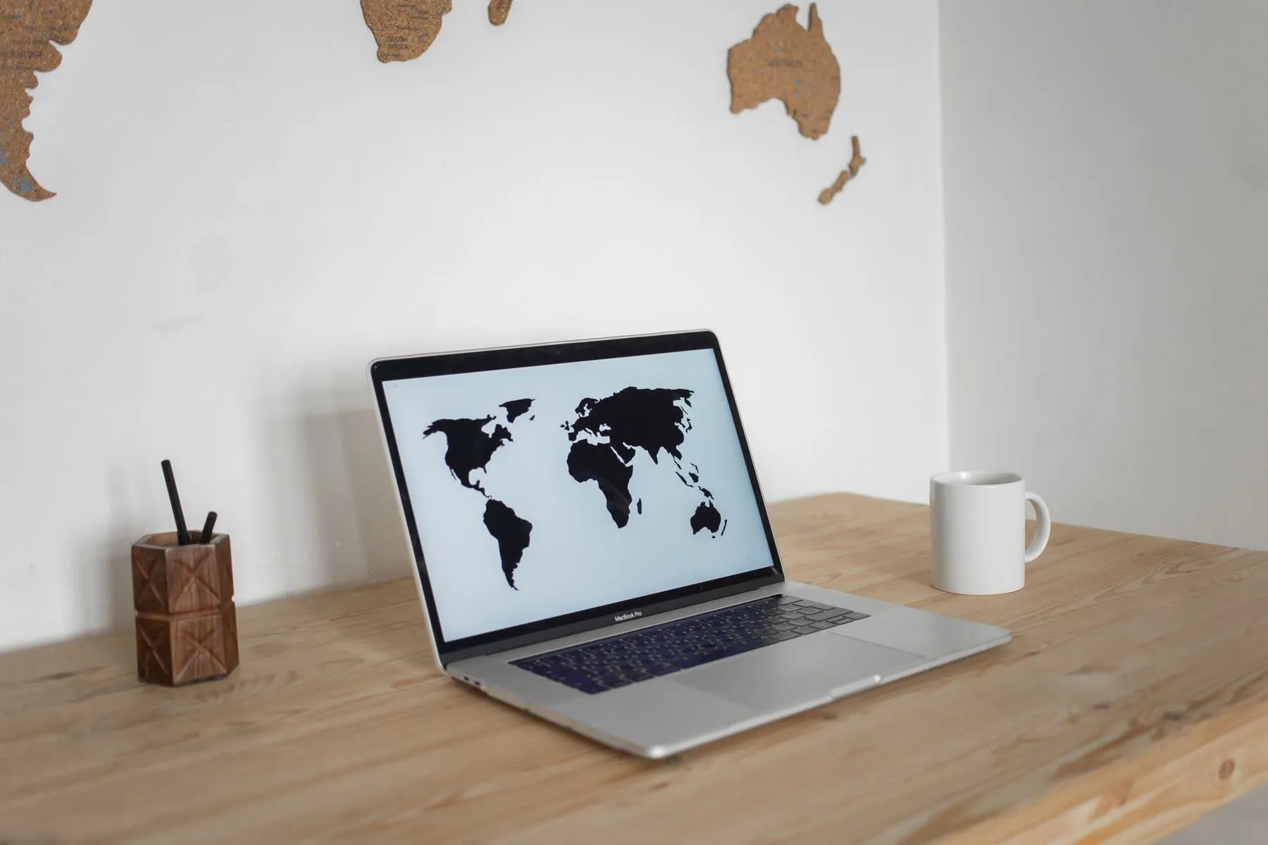 Laptop sobre a mesa mostrando um mapa-múndi.